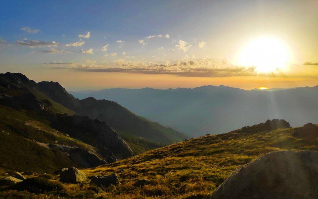 Coucher de soleil sur les crêtes du Jura, pelouse d'altitude et vallée noyée dans la brume.