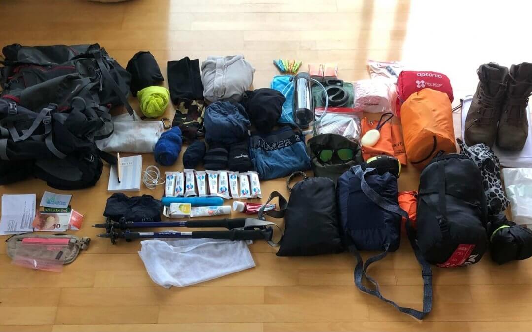 Matériel de randonnée disposé au sol pour préparer le sac à dos du GR20 : équipement de trek et affaires de bivouac